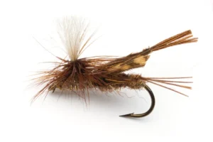 Närbild av en brun torrfluga, Parachute-variant för flugfiske, bunden med vit vinge och hackelfjädrar för att imitera en dagslända på vattenytan.