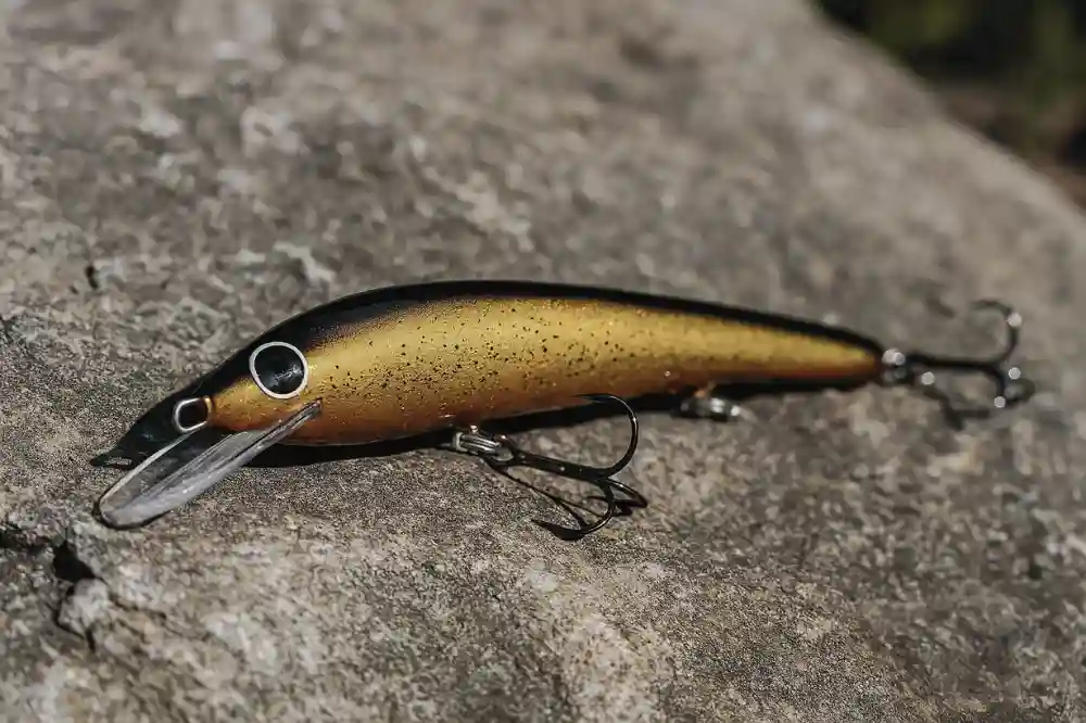 Wobbler i naturfärger placerad på sten, ett vanligt spinnbete för aktivt gösfiske i skymning och natt.